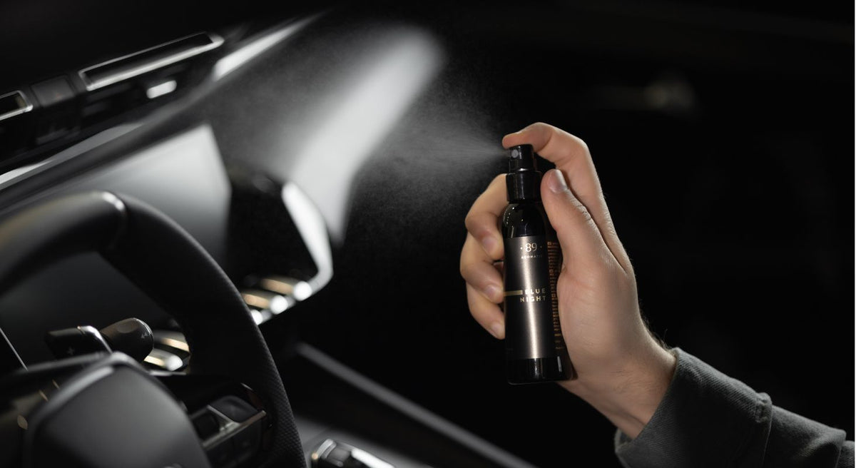 Spraying Aromatic 89 car fragrance in a car