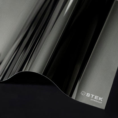 Close-up of black PPF with STEK logo on a dark background