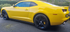 Yellow sports car parked on a road with a blurred background